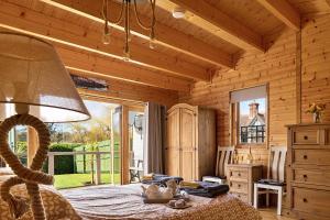 ein Schlafzimmer mit einem Bett in einer Holzhütte in der Unterkunft Finest Retreats - Garden Lodge in Craven Arms