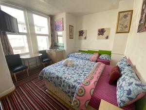 a bedroom with a bed and a table and windows at Mellory hotel in Blackpool