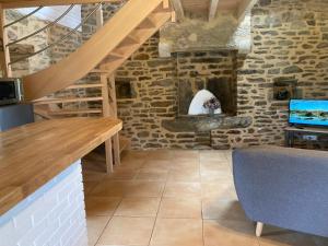 a kitchen with a wooden counter and a stone wall at Le Clos de Kermadec in Kervignac