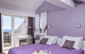 a bedroom with a purple bed with a view of the ocean at Apartments Milka & Miho in Dubrovnik