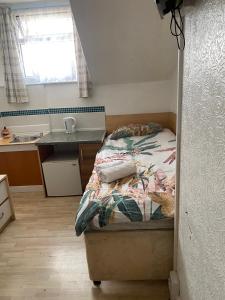 a small bedroom with a bed and a sink at Mellory hotel in Blackpool