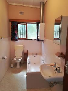 a bathroom with a tub and a toilet and a sink at Franskraal-Bit of Salt-Rustic Family Beach House-From R1650 per night, sleeps 6,min 2 nights in Franskraal