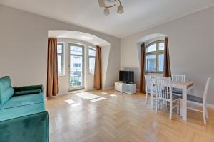 a living room with a couch and a table and chairs at Grand Apartments - Lemon - Monte Cassino in Sopot