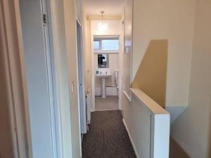 a hallway leading to a bathroom with a sink at Nice Residential Within Easy Reach To Town in Manchester