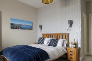 a bedroom with a bed with a blue and white blanket at The Kendrick Exclusively for adults in Llandudno