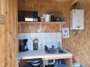 a small kitchen with a sink and a microwave at Yourtes 6 personnes proche provins et disney in Bannost