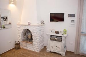 a living room with a stone fireplace with a tv at B&B Medali in Vernole