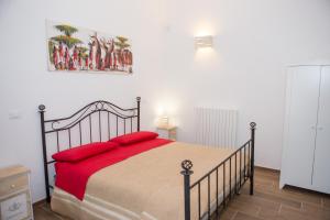 Un dormitorio con una cama con almohadas rojas. en B&B Medali, en Vernole