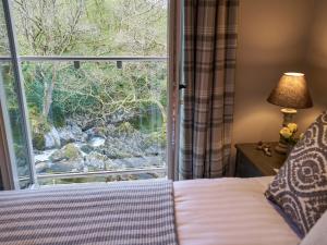 Un dormitorio con una cama y una ventana grande. en The Old Water Mill, en Kendal