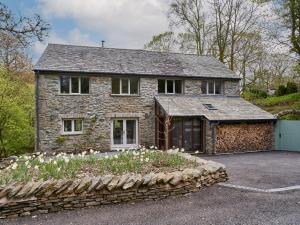 una casa de piedra con un jardín delante en The Old Water Mill, en Kendal