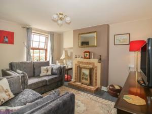 a living room with a couch and a fireplace at Rose Cottage in Ipswich