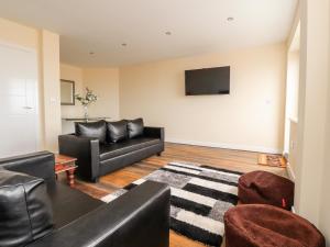 ein Wohnzimmer mit einem Sofa und einem TV in der Unterkunft The Beach House in Cleveleys