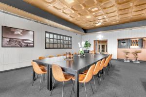 a conference room with a black table and chairs at Robukta Lodge l Jacuzzi l Sauna l Table Tennis in Tromsø