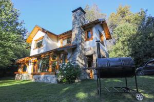 a house with a grill in front of it at Al pie del Campanario in San Carlos de Bariloche