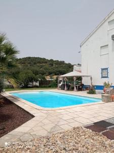 a swimming pool in front of a white building at Monte de Stª Margarida II in Montemor-o-Novo