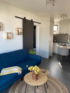 a living room with a blue couch and a table at Maison Lunette in Koksijde +8 photos