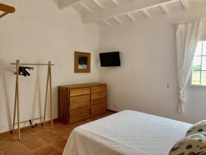 1 dormitorio con 1 cama, vestidor y TV en Islanders Menorca Country Club, en Son Carrio