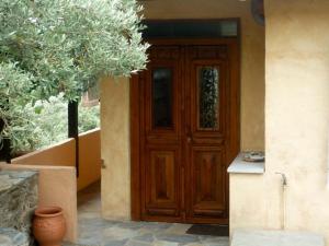 a wooden door of a house with a plant at Studio south Pilion in Chorto