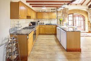 eine Küche mit Holzschränken und einer Arbeitsplatte in der Unterkunft Host & Stay - The Arches Cottage in Brotton