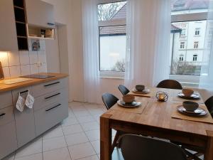 a kitchen with a wooden table and some chairs at M-OASE Wohlfühlen an der Oker I Küche I Netflix in Braunschweig