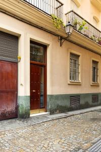 - un bâtiment avec une porte marron et un balcon dans l'établissement Villa Araucana, à Cadix