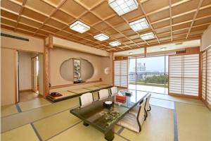 a living room with a table and a large window at Shirahama Onsen Kisyu Hanto in Shirahama