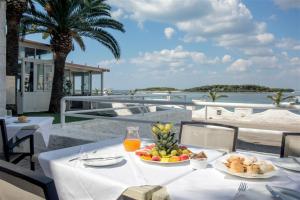 - une table avec une assiette de fruits et de jus sur un balcon dans l'établissement Hotel Lo Scoglio, à Porto Cesareo