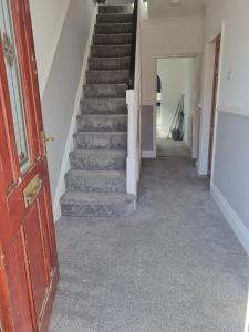 a hallway with stairs in a house at Collins Avenue in Norton