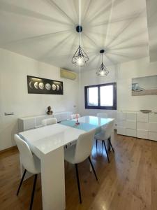 een eetkamer met een witte tafel en stoelen bij MiCasaEsTuCasa in Porto Santo Stefano