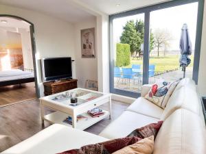 een woonkamer met een witte bank en een tv bij Vakantiewoning Goedgelegen MB01 in Middelburg