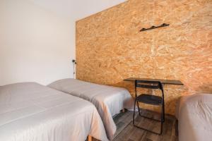 Cette chambre comprend deux lits, une table et une chaise. dans l'établissement Le Dortoir des Templiers, à Enquin-les-Mines