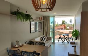 a living room with a couch and a table at Areias do Mar ! 3 quartos com Varanda A212 in Barra de São Miguel
