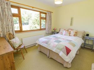 1 dormitorio con cama y ventana en Ceris en Penrhyndeudreath