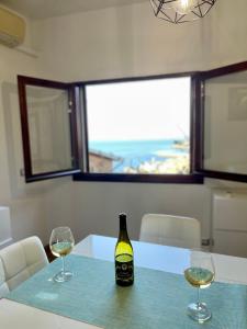 una botella de vino sentada en una mesa con dos copas en MiCasaEsTuCasa, en Porto Santo Stefano