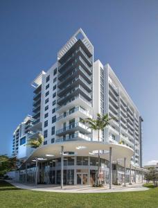 un grand bâtiment blanc avec des palmiers devant lui dans l'établissement Desing district, great apartment, à Miami
