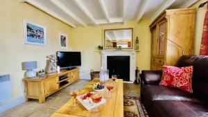 a living room with a couch and a table with wine glasses at Thornwell Cottage - Heart of the village, amazing gardens, glorious views and brimming with character in Dittisham