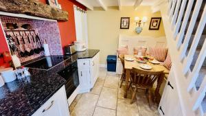 a kitchen with a table and a small table and chairs at Thornwell Cottage - Heart of the village, amazing gardens, glorious views and brimming with character in Dittisham