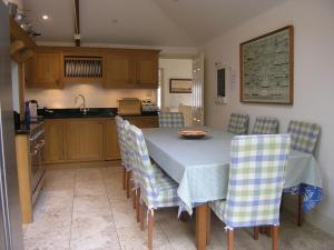 Una cocina con una mesa y sillas en una habitación. en Dunedin - Waterside location, private garden and buckets of charm, en Dittisham