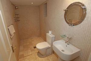 Un baño con inodoro, lavabo y espejo. en Dunedin - Waterside location, private garden and buckets of charm, en Dittisham 15 fotos más