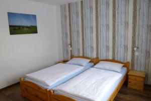 two twin beds in a room with a wall at Pension Wittgensteiner Schweiz in Bad Berleburg