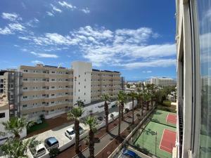 een uitzicht op een stad met palmbomen en gebouwen bij EL DORADO HOLIDAYS in Playa de las Americas