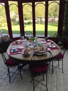 - une table en bois avec des chaises autour de la table et de la nourriture dans l'établissement Le Dortoir des Templiers, à Enquin-les-Mines
