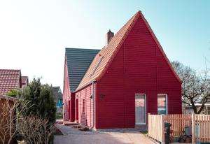 un edificio rojo con techo de gambrel en Ferienwohnung Rote Kate, en Born
