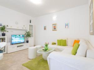 Biały salon z białą kanapą i telewizorem w obiekcie Green Magic Apartment w Dubrowniku
