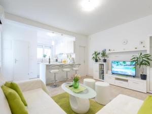 Biały salon z kanapą i telewizorem w obiekcie Green Magic Apartment w Dubrowniku