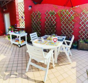 a white table and chairs and a red wall at Starnone Bed&Book in Naples