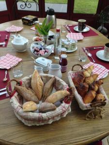 a table with a basket of bread and pastries on it at Le Dortoir des Templiers in Enquin-les-Mines +8 photos