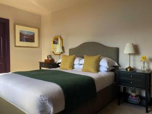 a bedroom with a large bed with yellow pillows at Ardvreck House in Ullapool