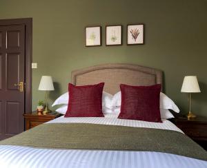 a bedroom with a large bed with red pillows at Ardvreck House in Ullapool