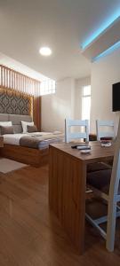 uma sala de estar com uma cama, uma mesa e cadeiras em Apartments "Tuffo" em Saraievo